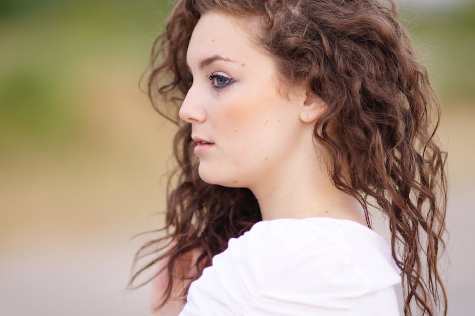 young woman performing gentle eye massage with fingers around eye area in peaceful setting